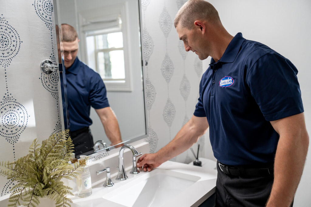 plumber turning on bathroom faucet