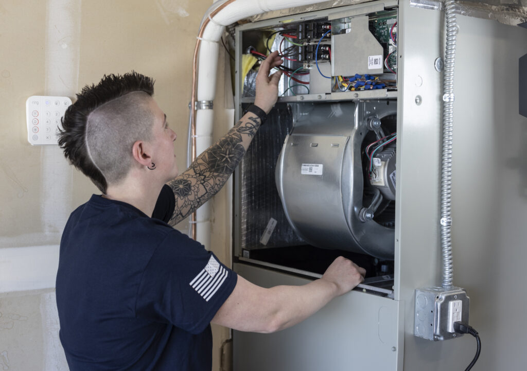 HVAC tech repairing furnace